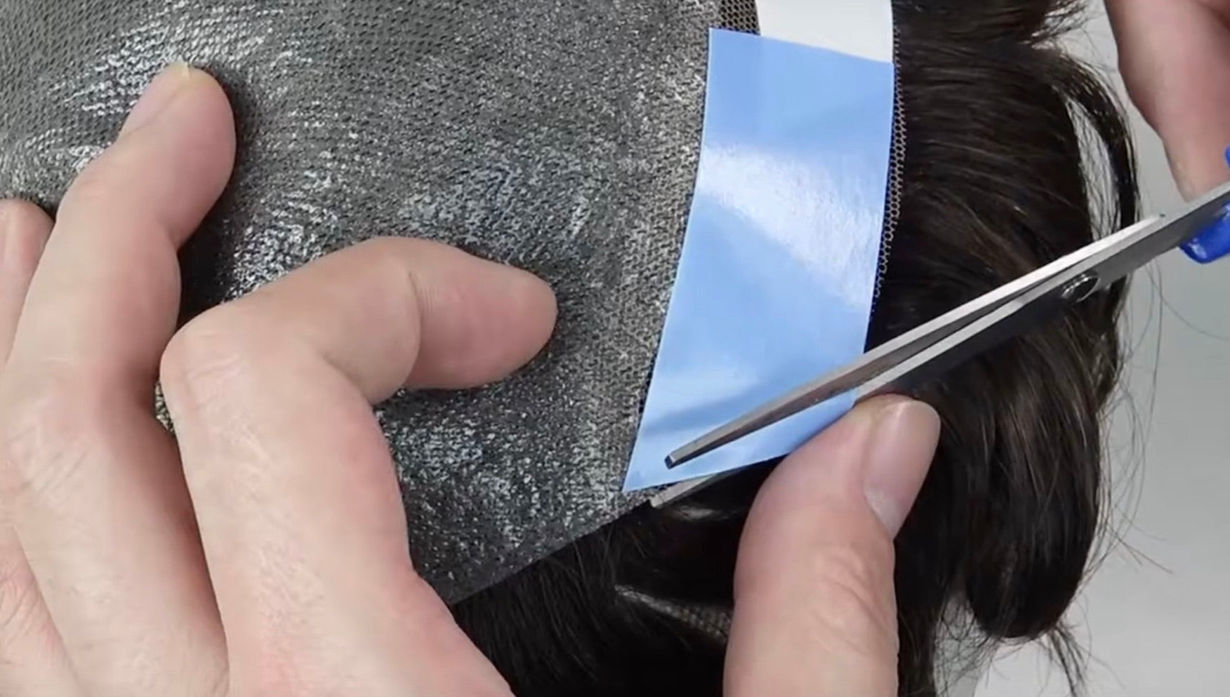 Klebestreifen für Haarteil werden eingeschnitten