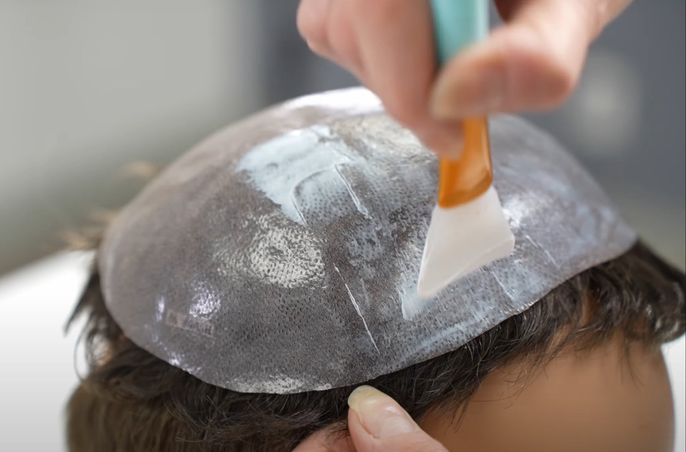 Flüssigkleber wird auf eine Folie aufgetragen